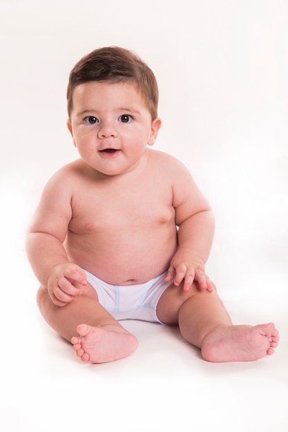 Piccolo neonato che si siede e che guarda l'obbiettivo. Bambino brasiliano.