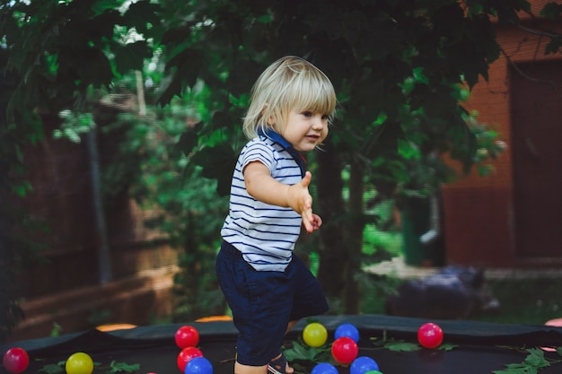 Piccolo neonato su un trampolino con palle colorate