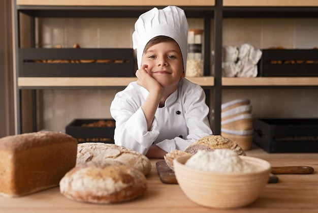 Piccolo panettiere sognante che lavora in negozio