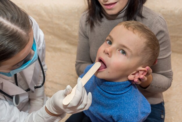 Piccolo paziente che mostra la sua gola al pediatra