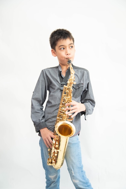 Piccolo ragazzo asiatico del musicista che gioca alla palestra