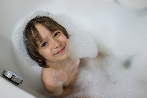 Piccolo ragazzo carino con bagnoschiuma