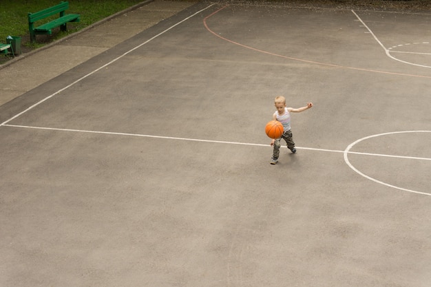 Piccolo ragazzo che gioca a basket