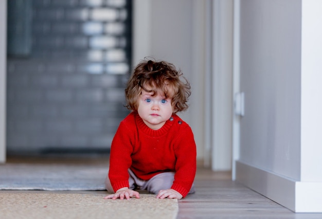 Piccolo ragazzo del bambino su un pavimento a casa