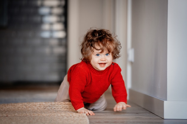 Piccolo ragazzo del bambino su un pavimento a casa