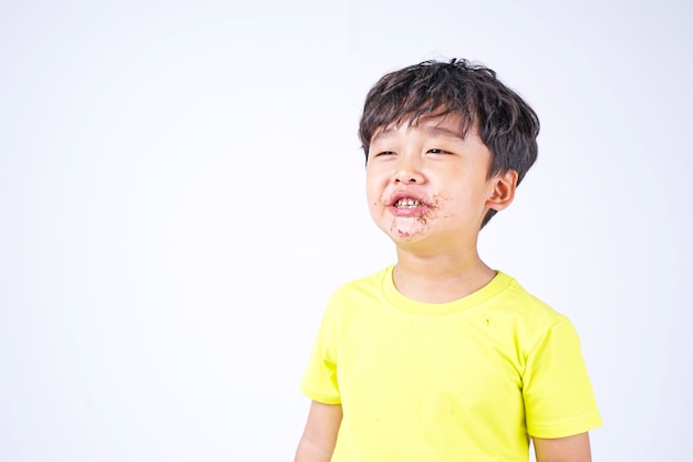 Piccolo ragazzo sveglio asiatico che mangia grande ciambella