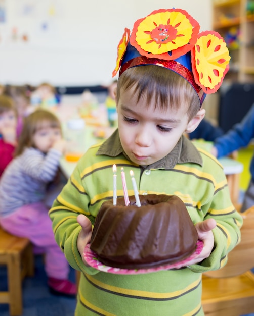 Piccolo ragazzo sveglio che ha festa di compleanno all&#39;asilo