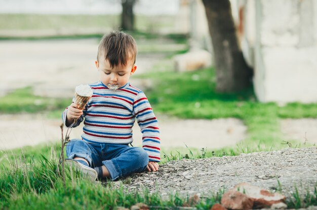 Piccolo ragazzo sveglio che mangia il gelato