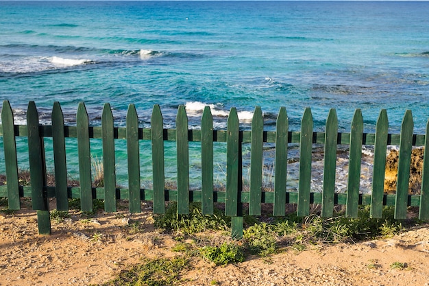 Piccolo recinto decorativo di legno verde sulla spiaggia.