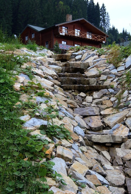 Piccolo rivolo scorre lungo le lastre di pietra e le rocce dalla casa di legno del paese su una collinetta