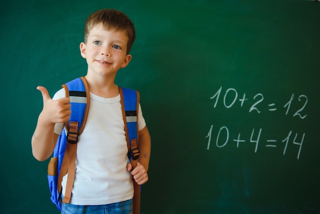 Piccolo scolaro sveglio che si siede nell'aula