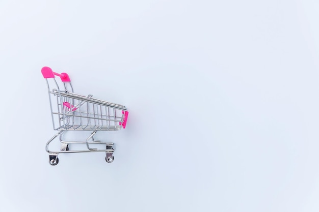 Piccolo supermercato drogheria carrello a spinta per lo shopping giocattolo con ruote isolato su sfondo bianco vendita b...