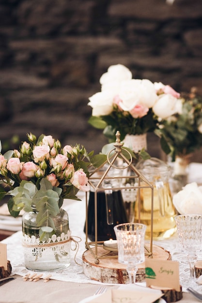 Piccolo tavolo da pranzo servito in stile rustico e decorato con fiori rosa