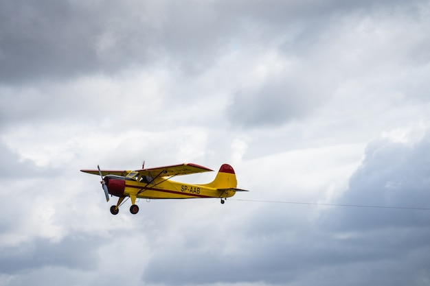 Piccolo volo dell'aeroplano del singolo motore nel cielo nuvoloso inglese