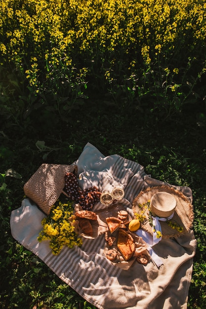 Picnic al tramonto al campo di colza bicchiere di vino cibo panino no people