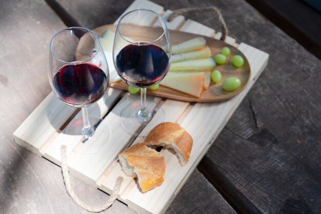 Picnic con calici di vino rosso, pane e formaggio