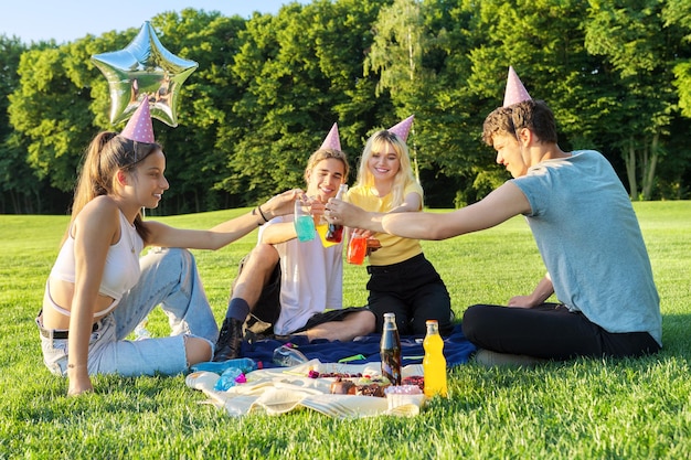 Picnic di festa di compleanno adolescente sull'erba nel parco