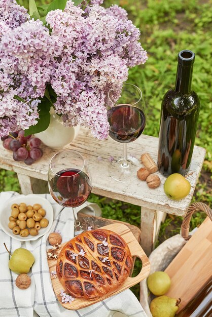 Picnic estivo in giardino Torta al vino frutta e fiori Natura morta Pranzo e tavola di Pasqua