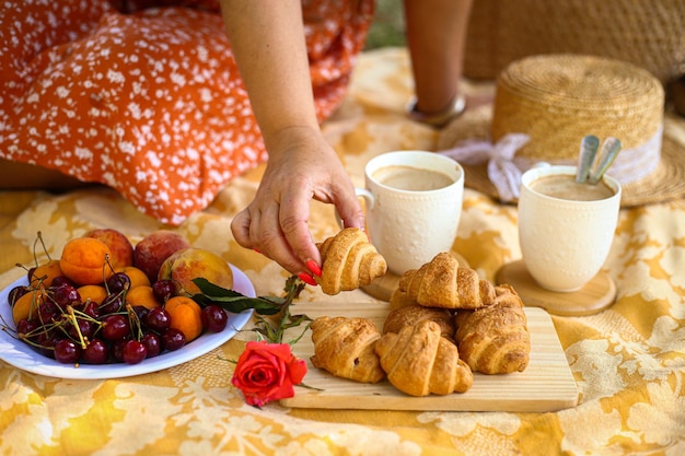 Picnic in natura in estate con libro di croissant e fiori