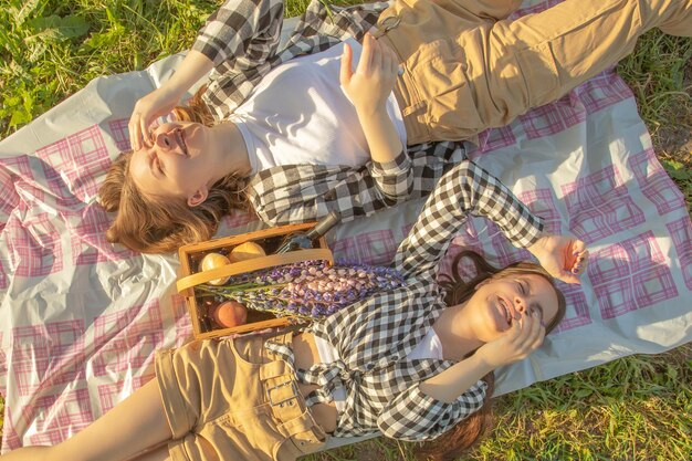 Picnic in natura Le ragazze si trovano sull'erba ridendo