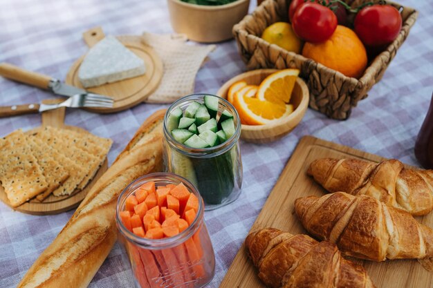 Picnic nel campeggio della foresta con verdure succo di formaggio e croissant vicino al fiume di montagna