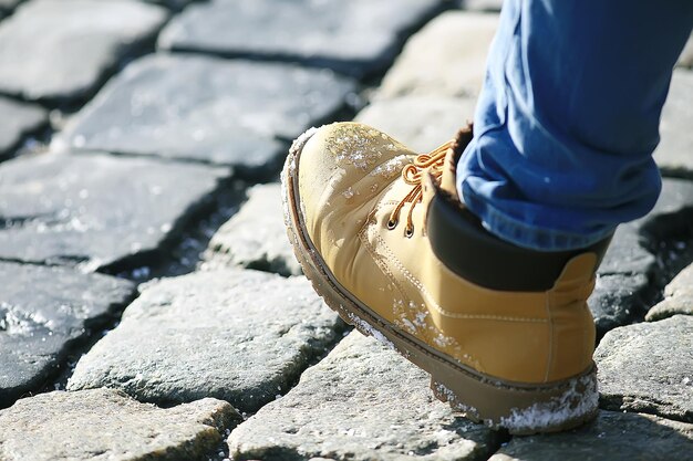 piede d'uomo in una scarpa su un selciato, un pedone,