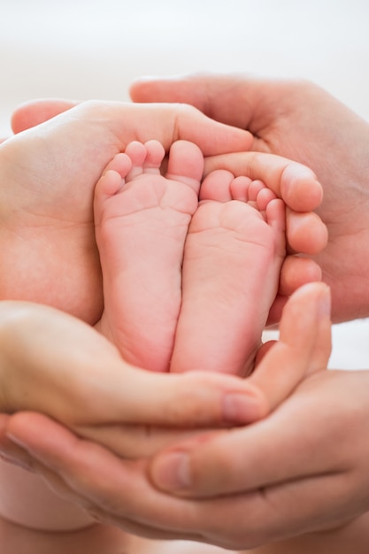 Piede del bambino nelle mani dei genitori, rosa