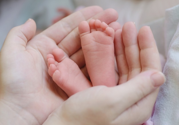 Piede del neonato nella mano della madre