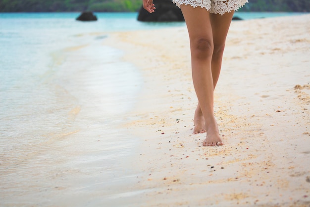 Piede della donna di viaggio sulla spiaggia