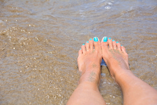 Piedi bagnati sulla riva della spiaggia