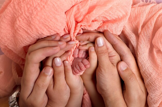 piedi del bambino nelle mani dei genitori in primo piano. un po' di felicità.