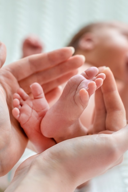 Piedi del bambino nelle mani della madre