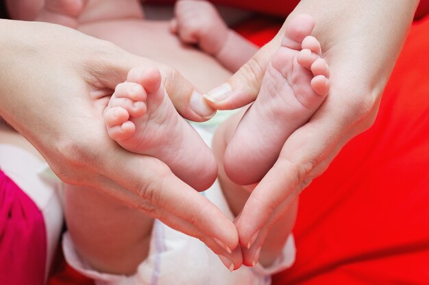 Piedi del bambino nelle mani della madre