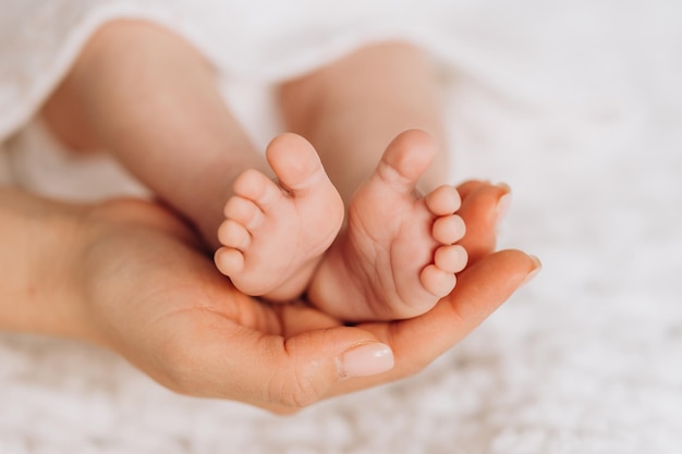 Piedi del bambino nelle mani delle madri Mamma e suo figlio Concetto di famiglia felice