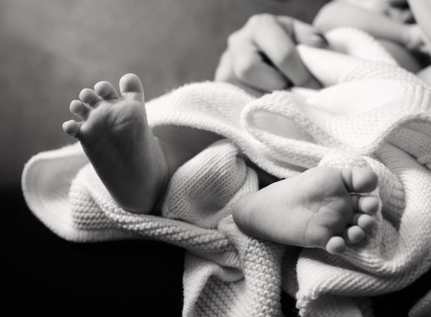 Piedi del bambino sdraiati in bianco e nero