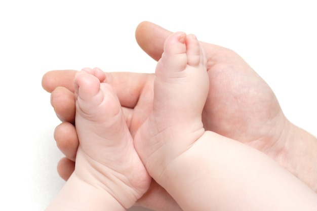 Piedi del bambino sdraiati sulla mano di un padre