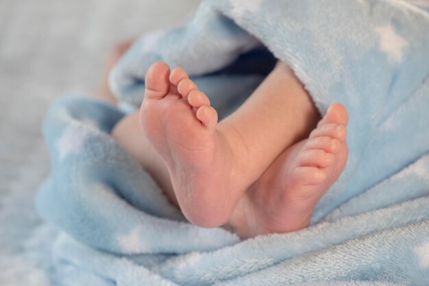 Piedi del bambino sul copriletto blu