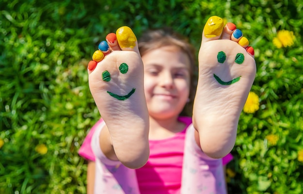 Piedi del bambino sull'erba disegnando un sorriso Messa a fuoco selettiva