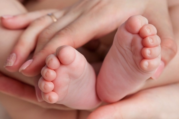 Piedi del neonato in primo piano della mano