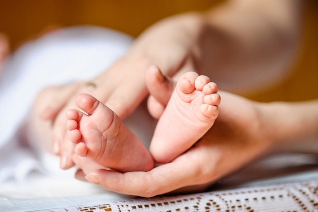 Piedi del neonato nelle mani della madre