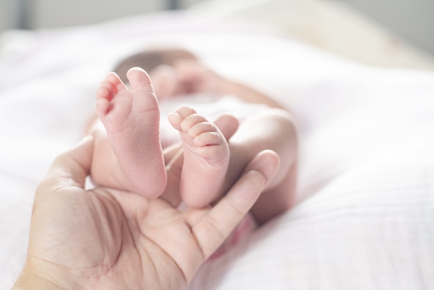 Piedi del neonato sulla mano dei genitori.