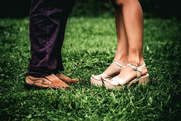 Piedi dell'uomo e della donna sull'erba verde