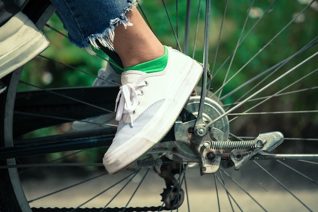 piedi della giovane donna in sella a una bicicletta