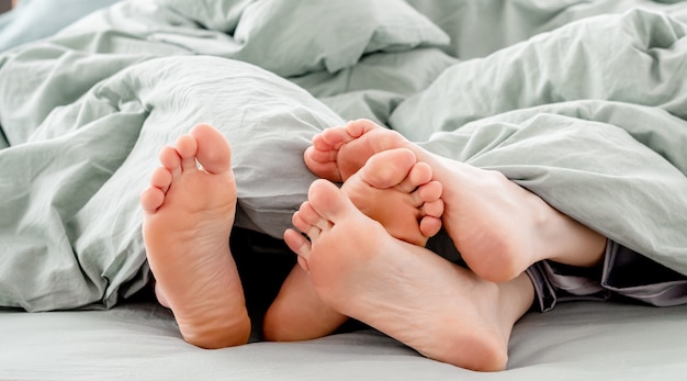 Piedi di coppia nel letto