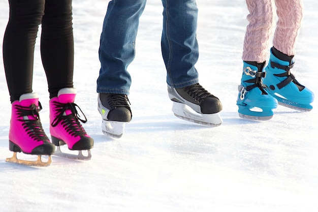 Piedi di diverse persone che pattinano sulla pista di pattinaggio. sport, hobby e svago di persone attive