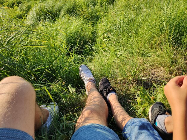 Piedi di papà e figlio nell'erba nel parco