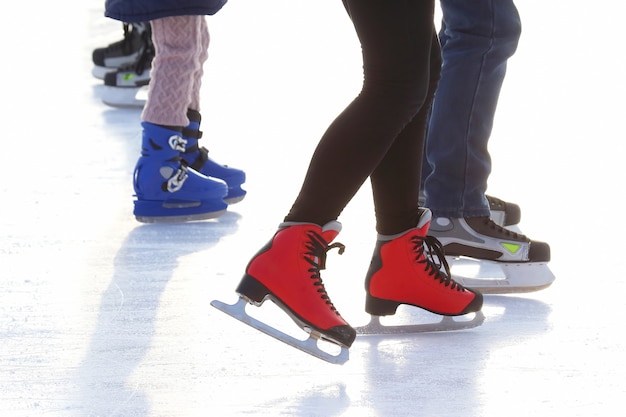 Piedi di persone diverse che pattinano sulla pista di pattinaggio