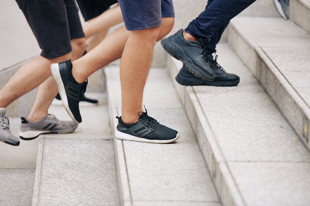 Piedi di sportivi che corrono su per le scale quando si allenano insieme per la maratona