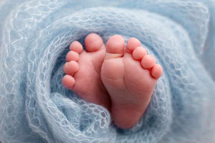 Foto piedi di un neonato. gambe su sfondo blu. piedi del bambino. foto di alta qualità