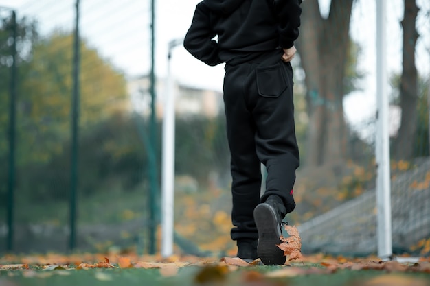 Piedi di un ragazzo che attraversa il campo di calcio.